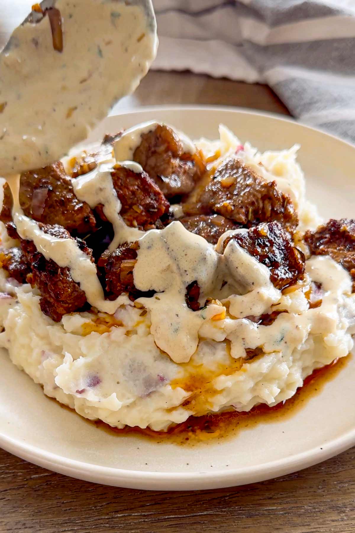 serving steak with creamy sauce on top