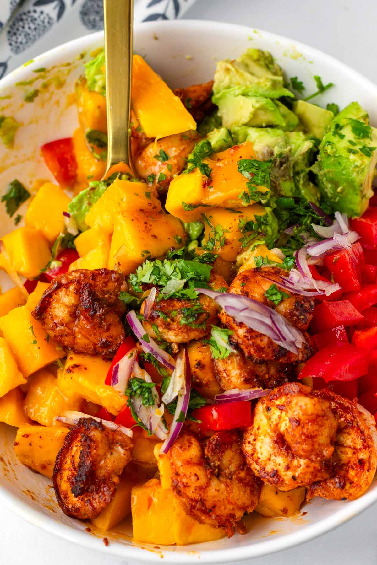 tossing the salad ingredients with the dressing