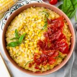 bowl of sweet yellow corn risotto with crispy prosciutto on top