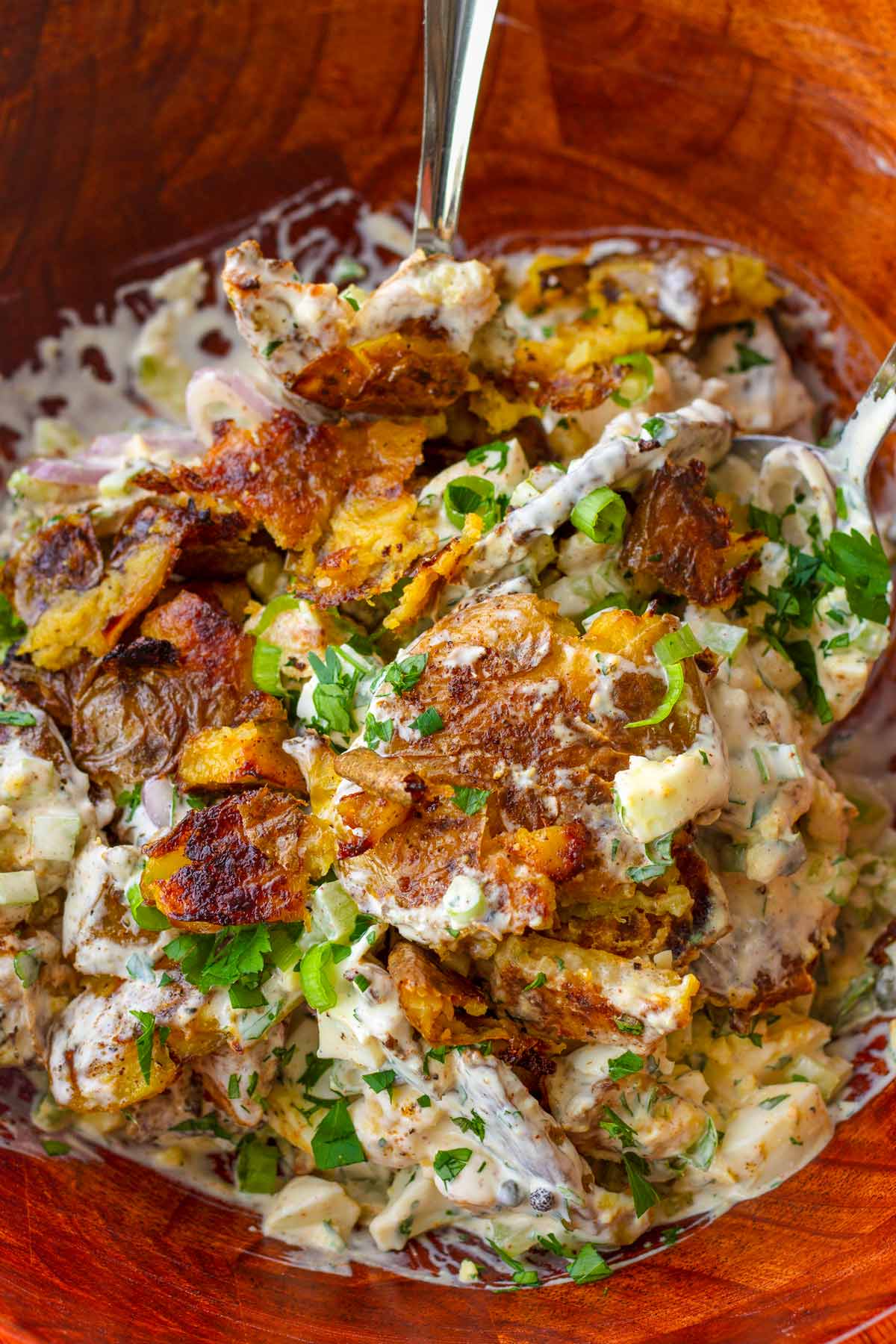creamy and crispy smashed potato salad served in a wooden bowl