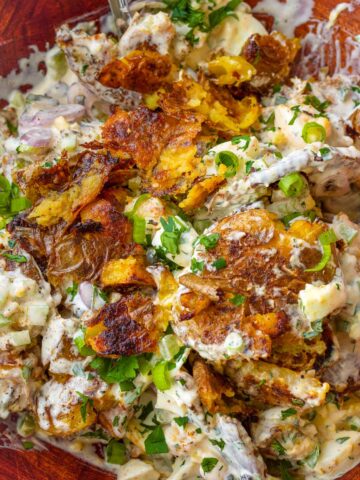 close up of crispy smashed potato salad with garnish