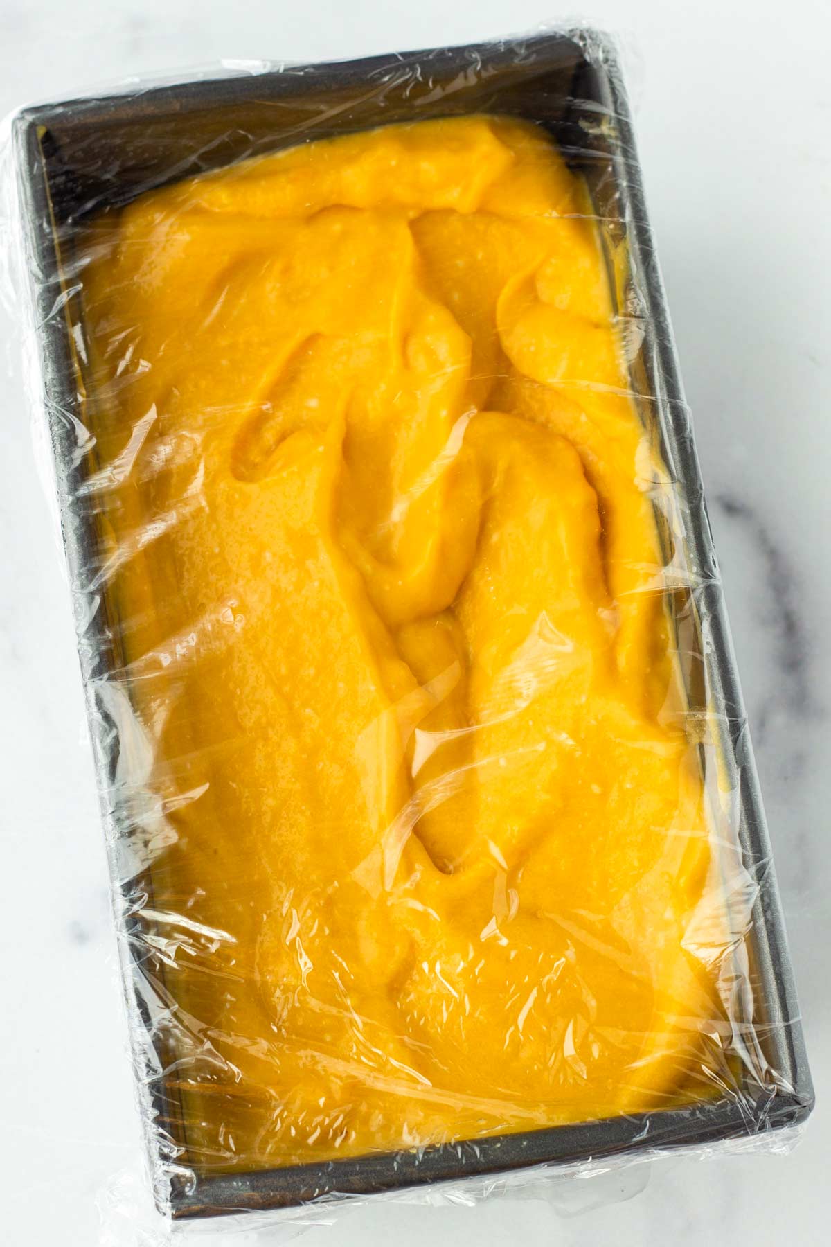sorbet mixture in a container wrapped with plastic for freezing