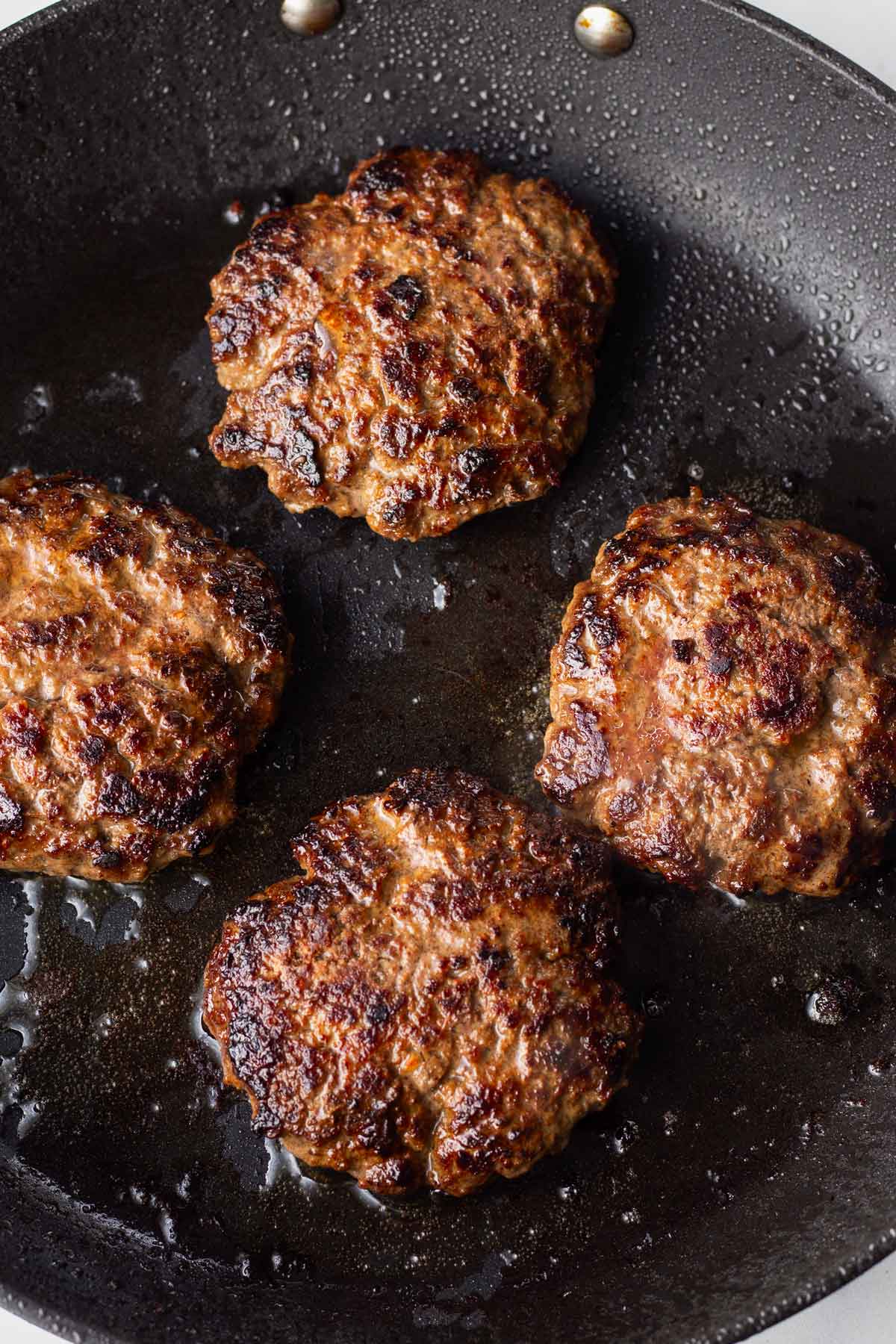cooking burgers in a skillet