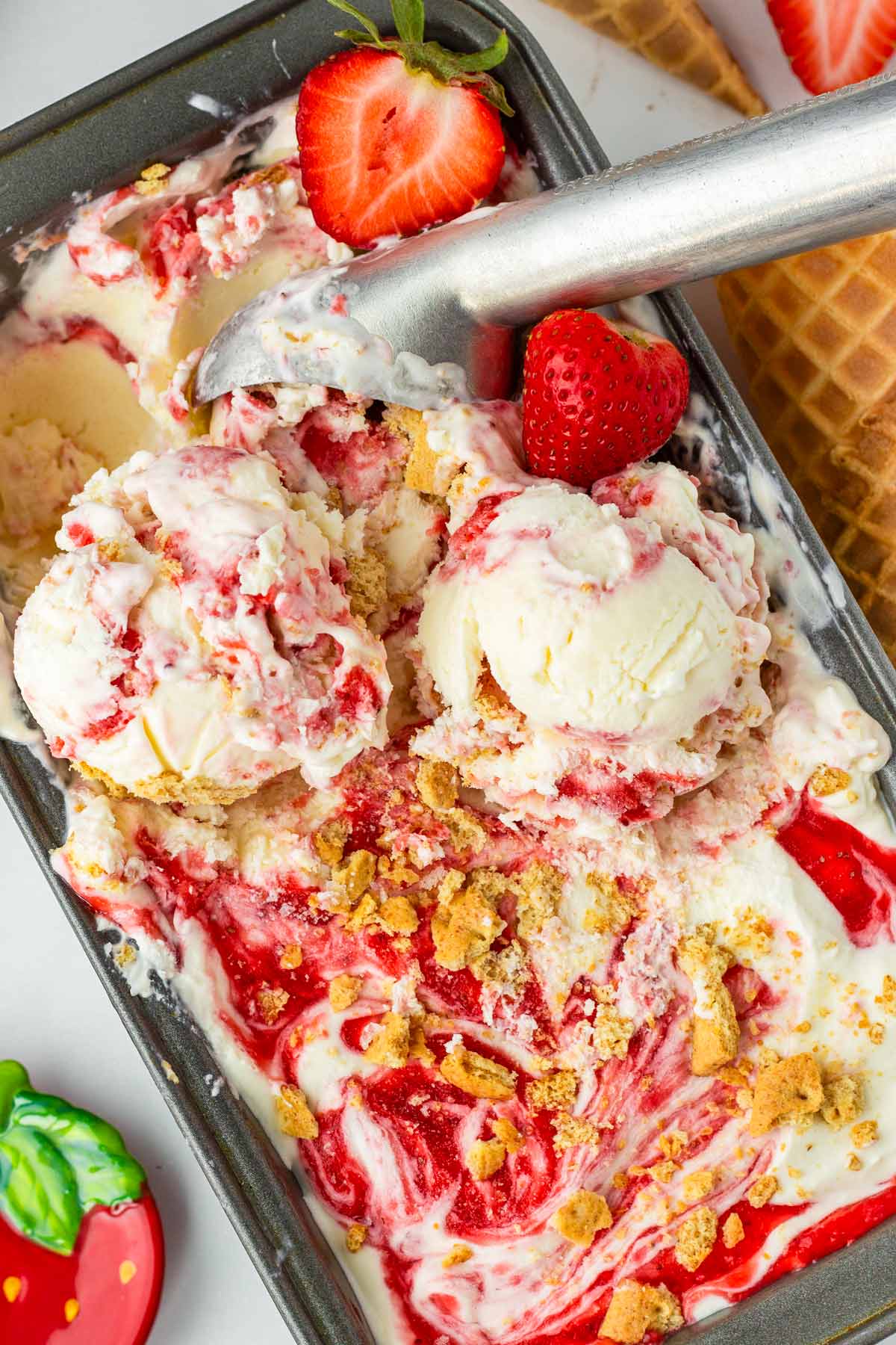 scooping out strawberry cheesecake ice cream from the container