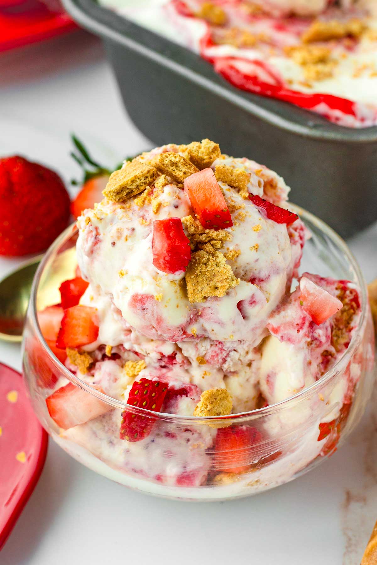 a small bowl with scoops of strawberry cheesecake ice cream