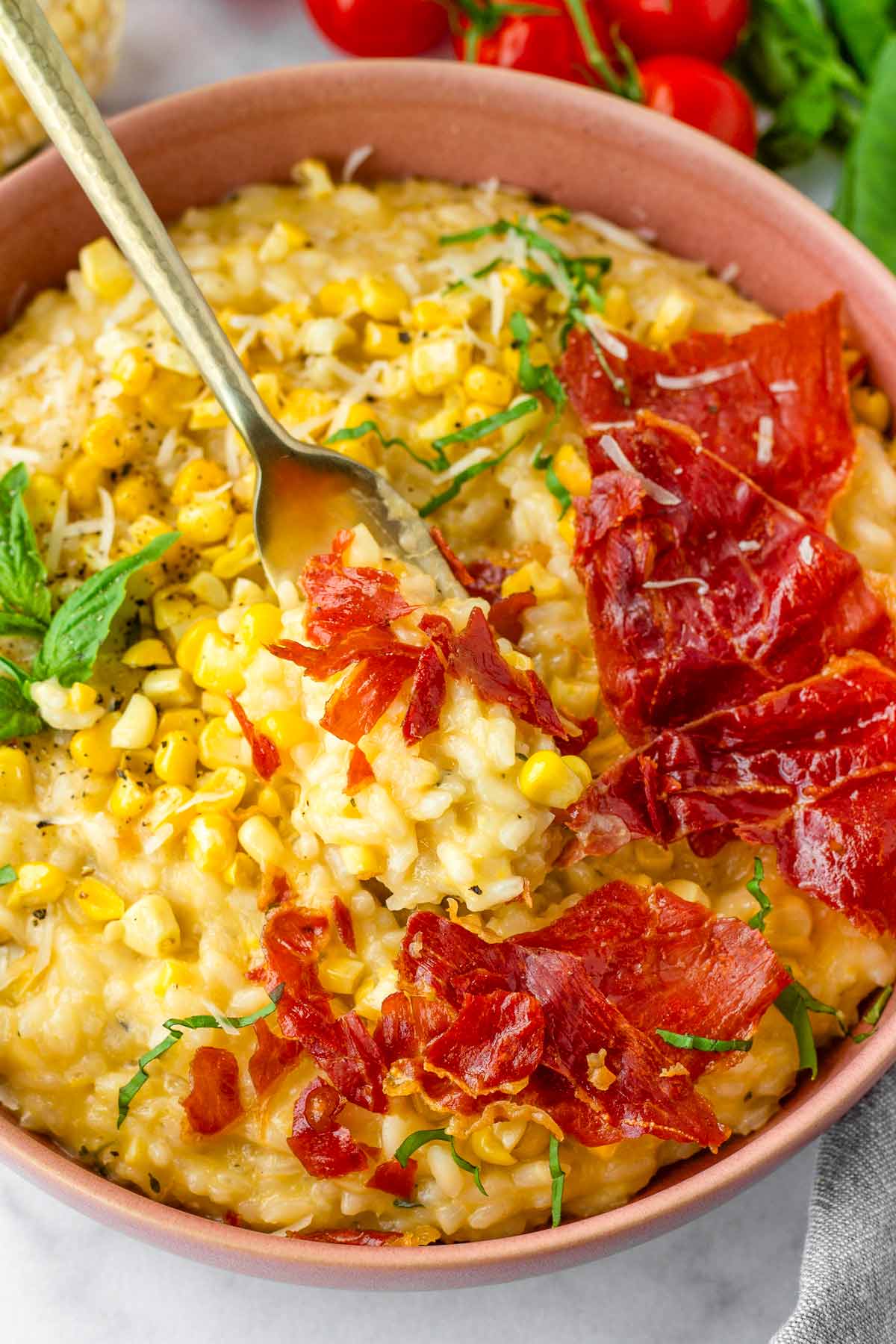 serving corn risotto and prosciutto with a fork