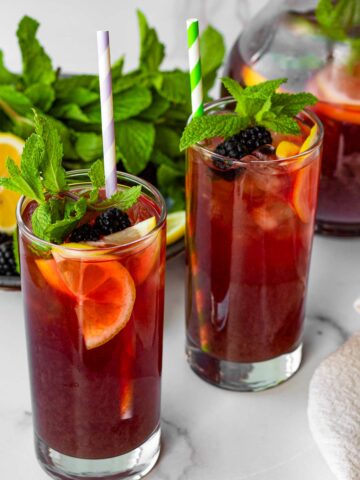 two glasses of blackberry iced tea with mint