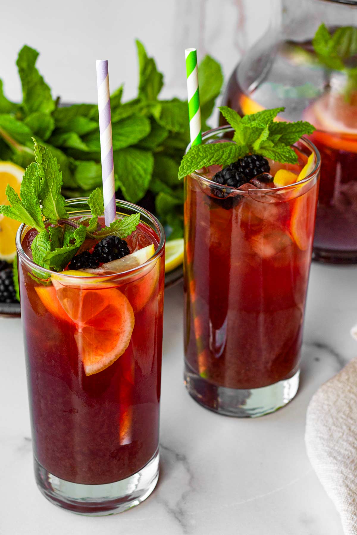 two glasses of blackberry iced tea with mint