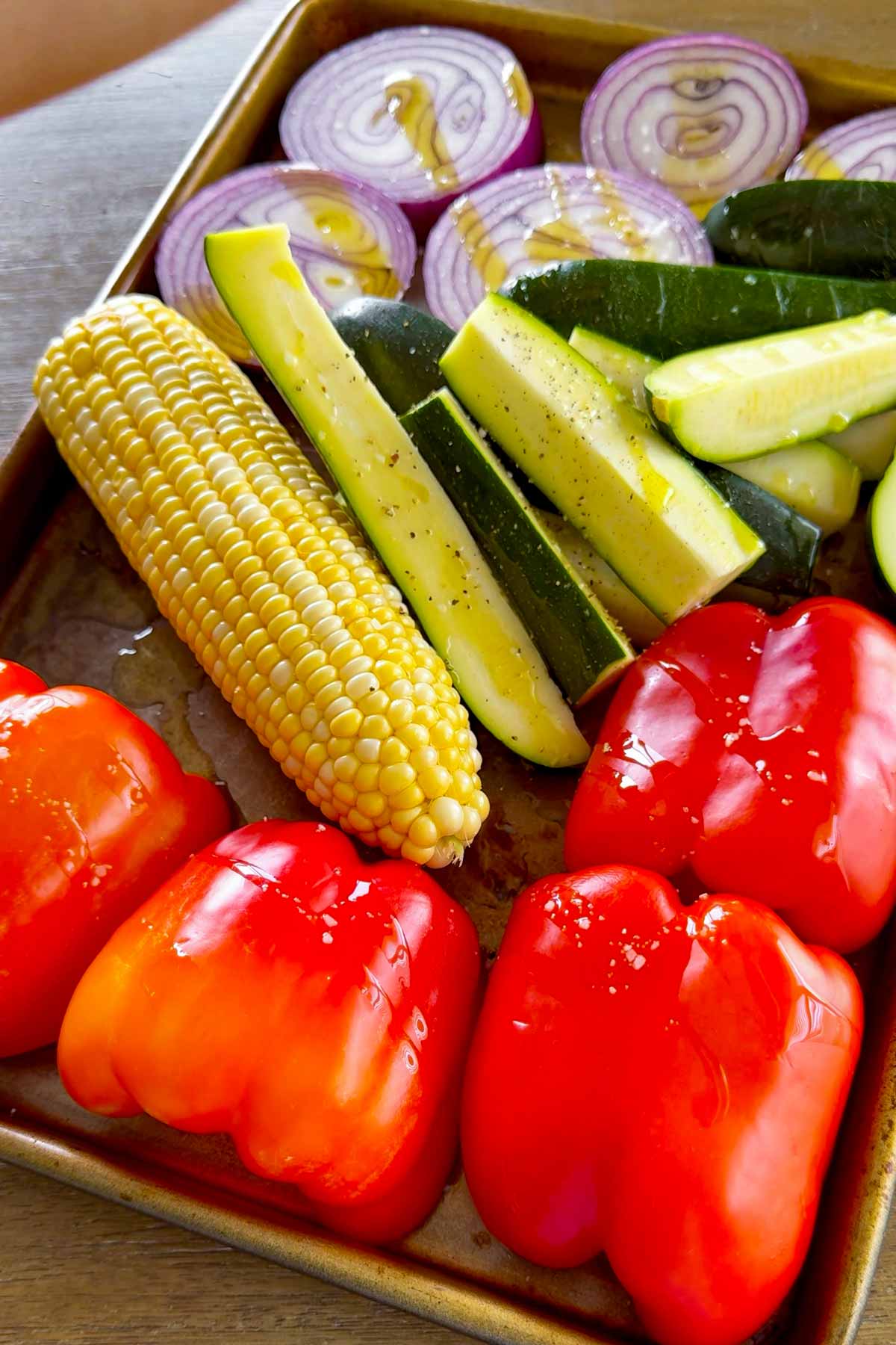 sliced vegetables seasoned and oiled on a tray