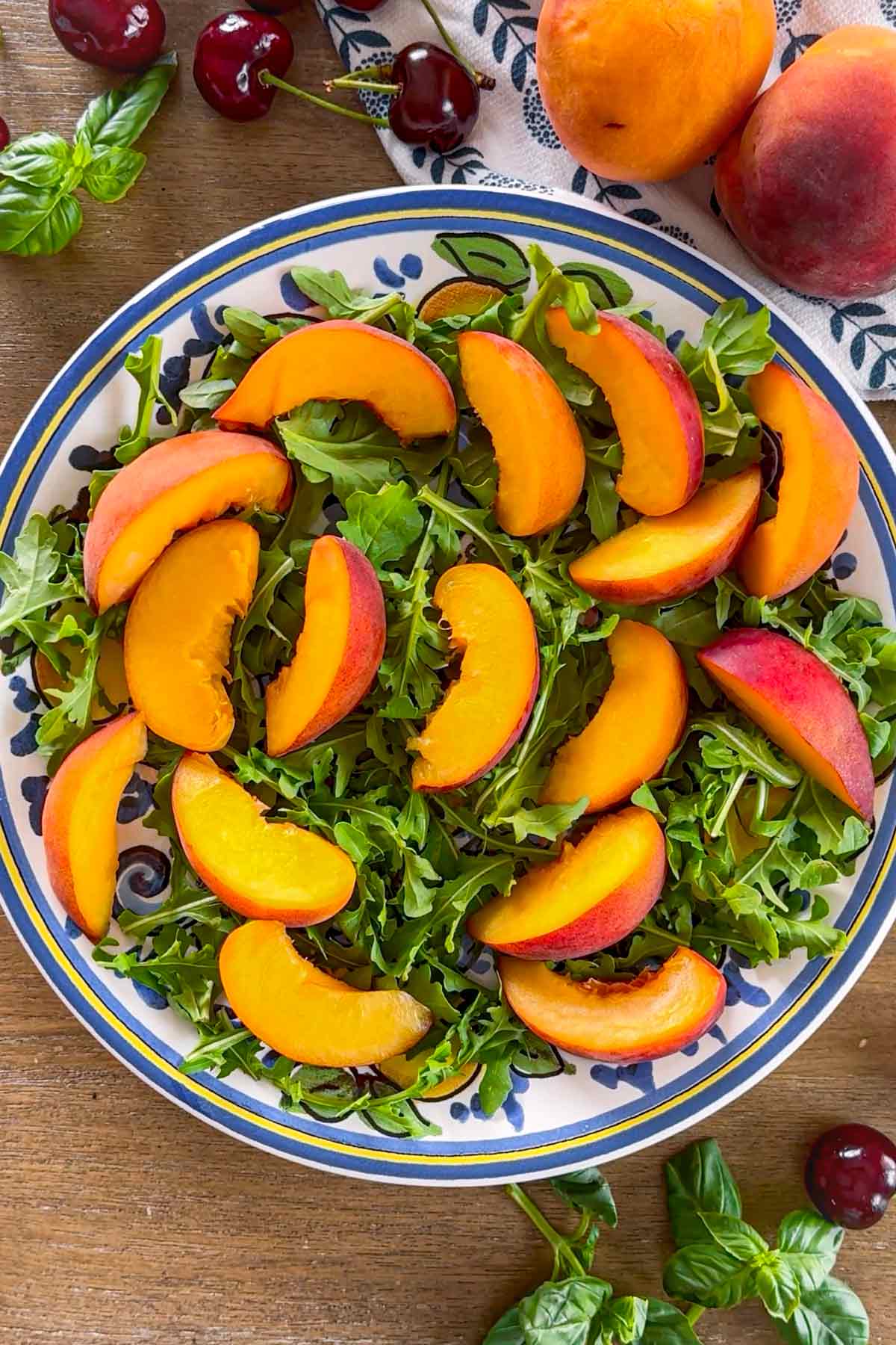 plate with arugula and sliced peaches on top