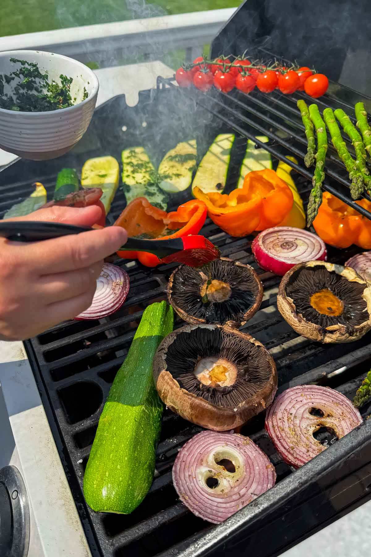 brushing the vegetables with chimichurri sauce on the grill