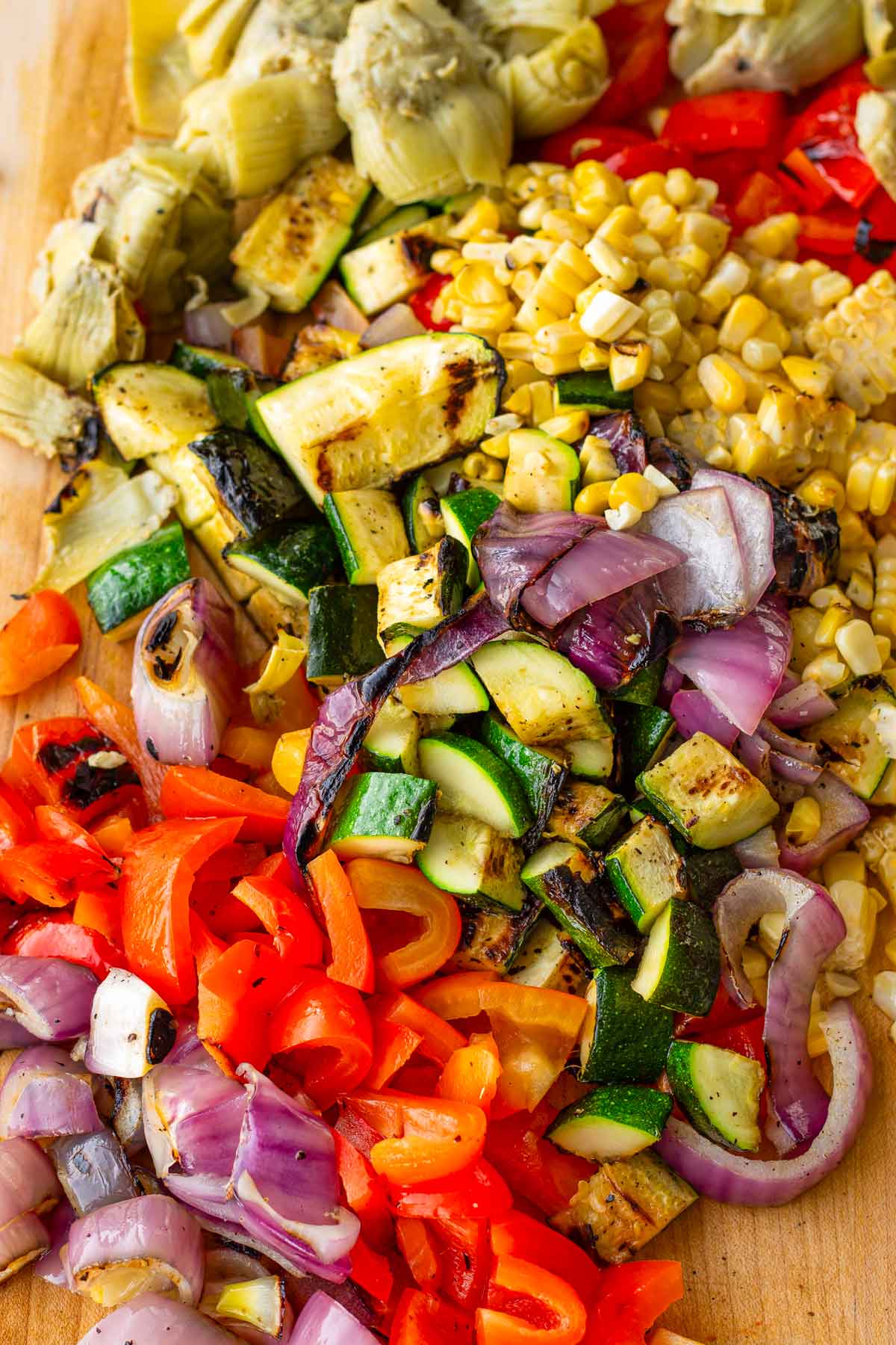 chopped grilled vegetables on cutting board