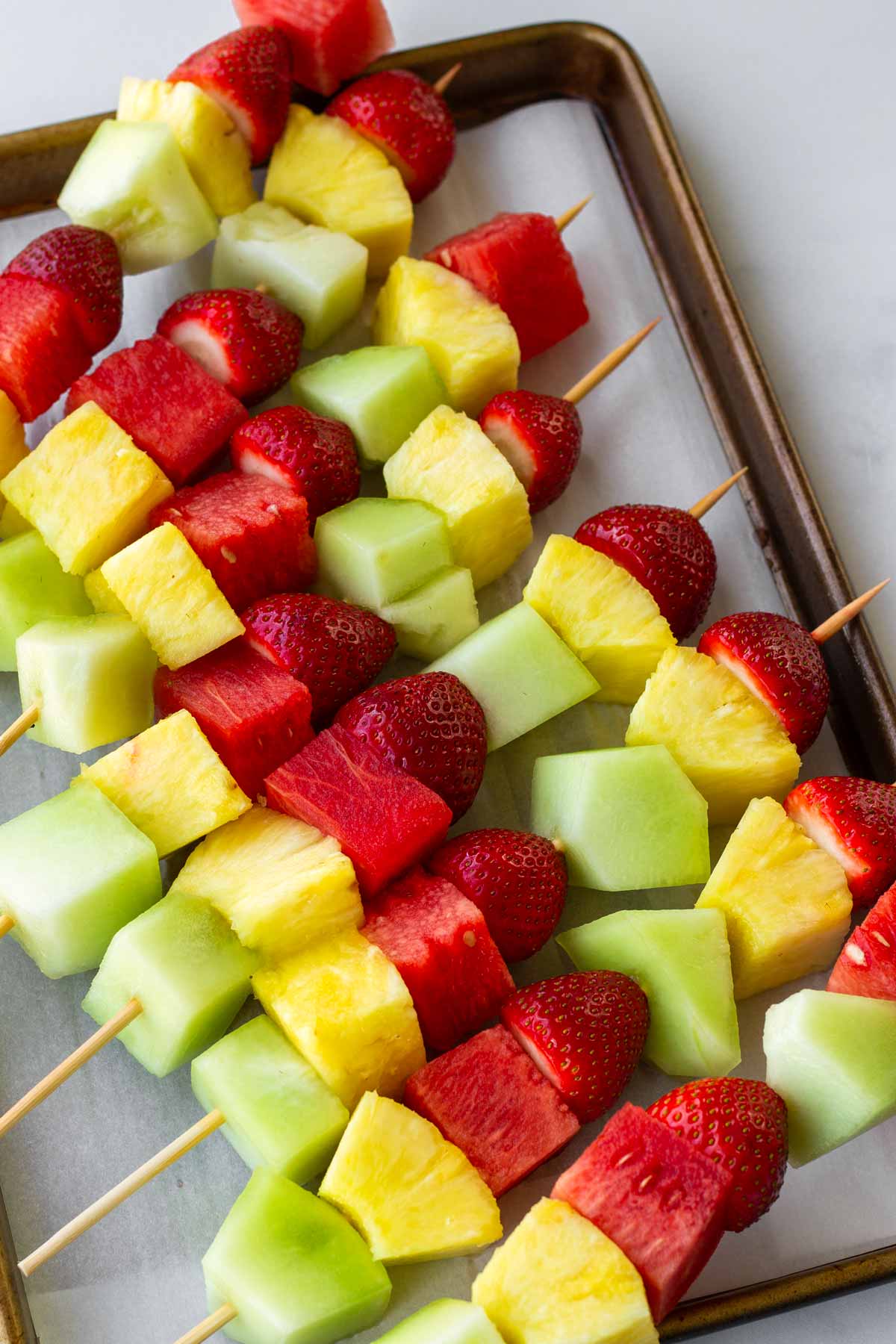assembled fruit kabobs in bamboo skewers