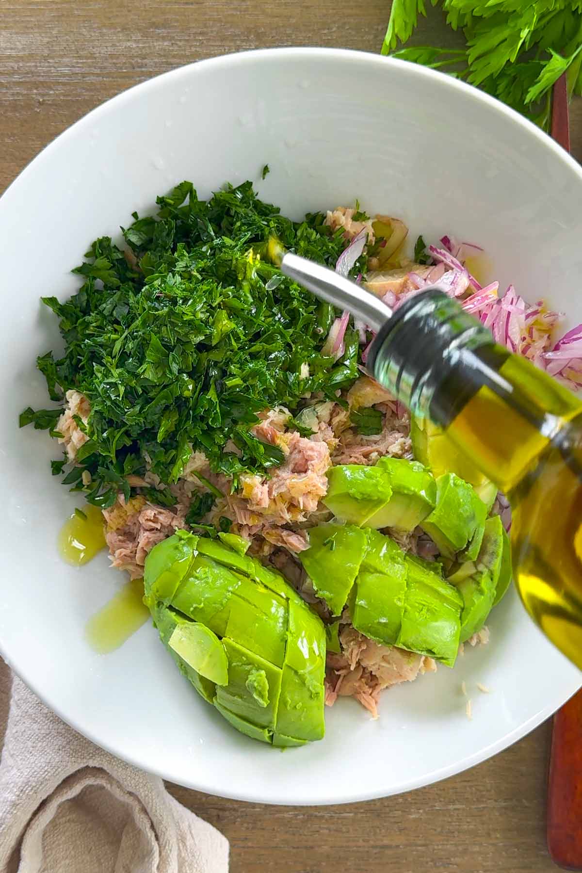 adding olive oil and condiments to salad