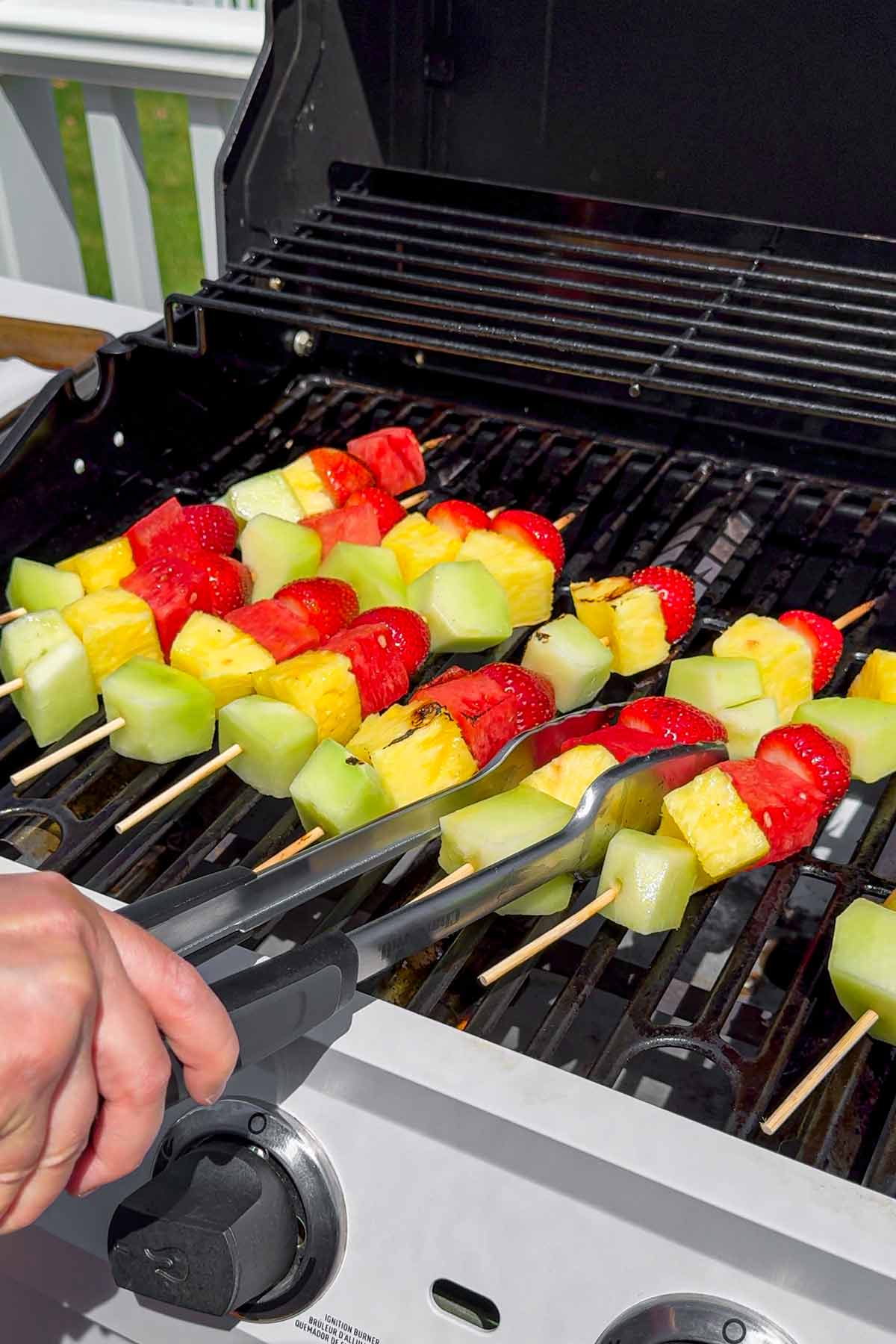 grilling assembled fruit kabobs in outdoor grill
