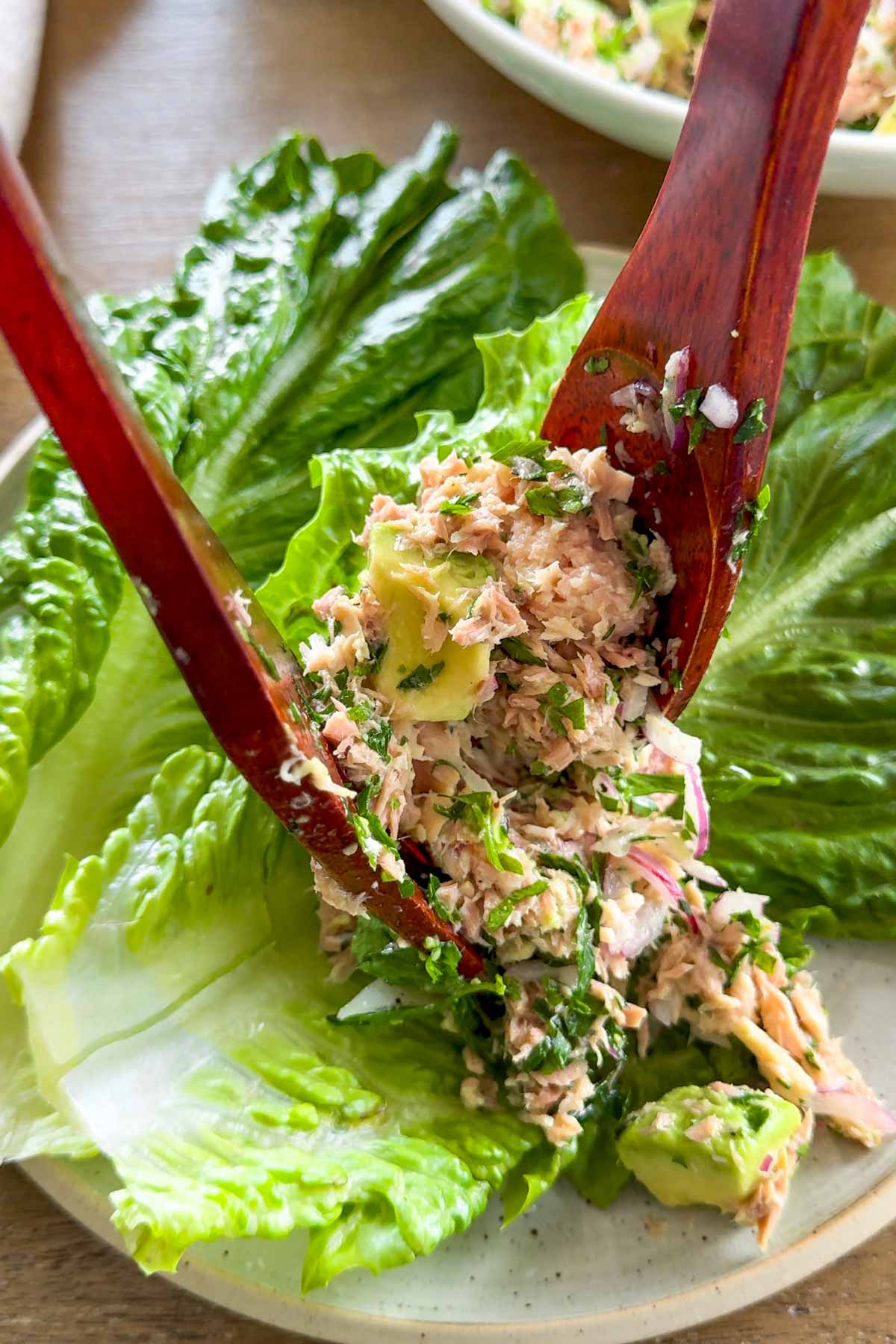spooning tuna salad over lettuce boats