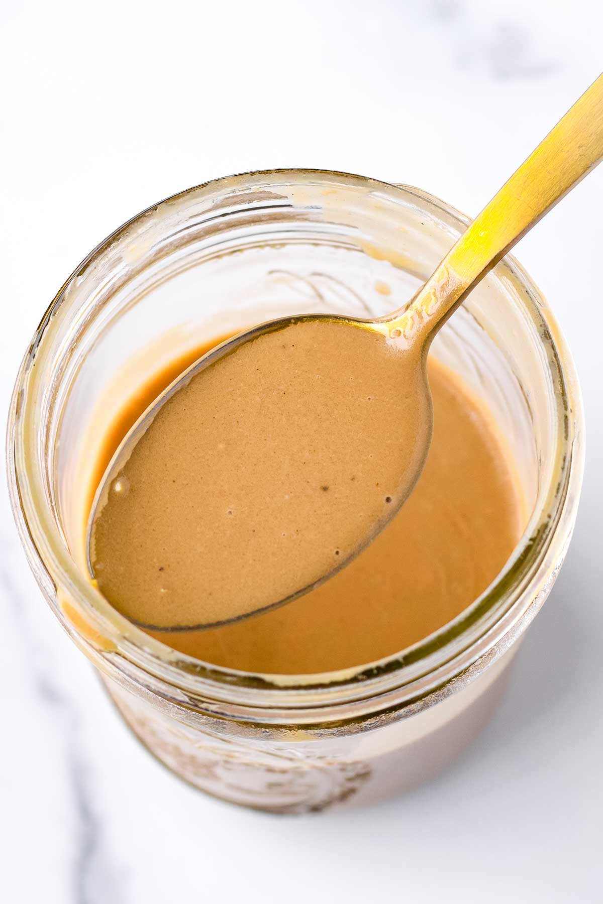 a spoonful of creamy balsamic dressing in mason jar