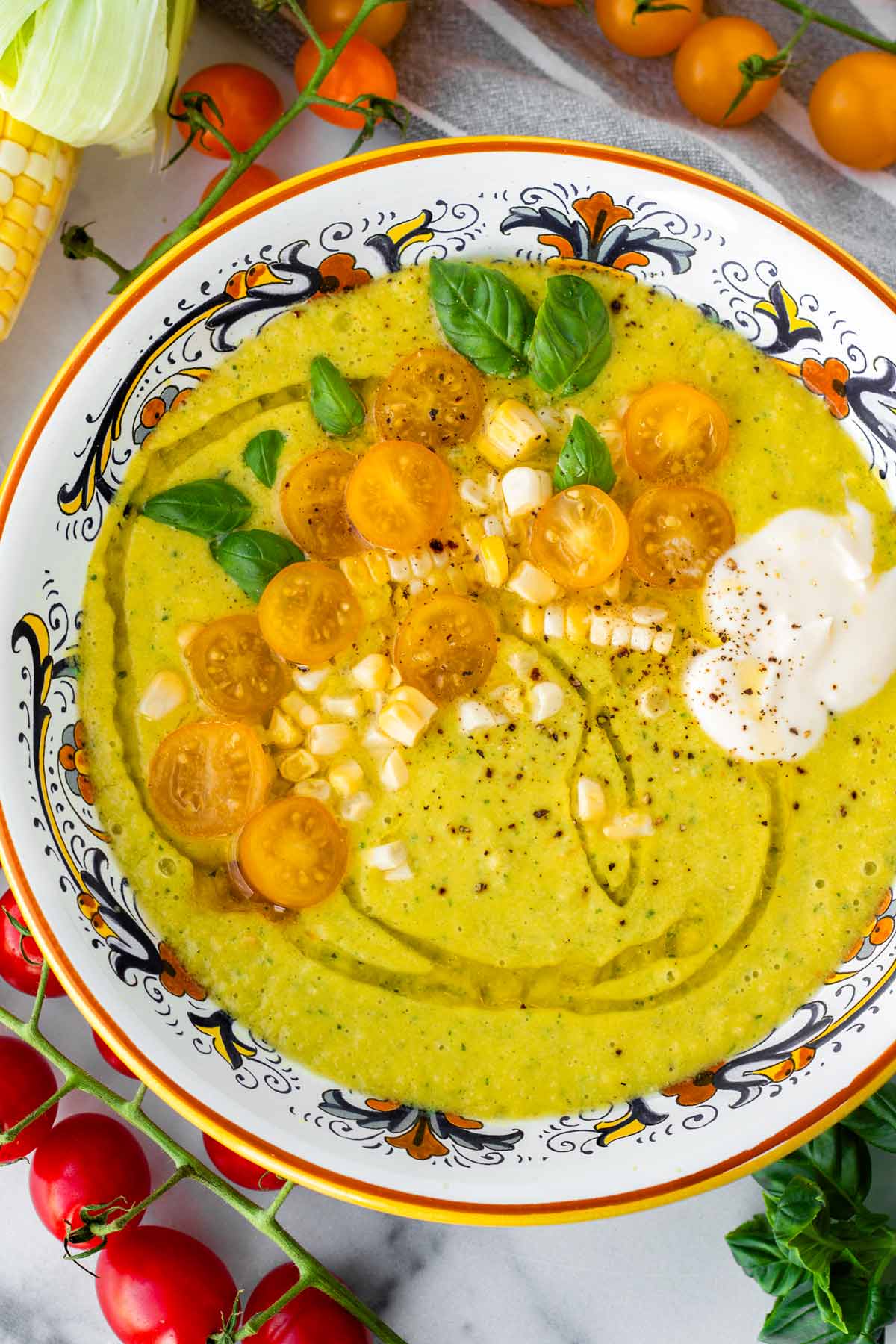 summer corn gazpacho with garnish in a colorful bowl