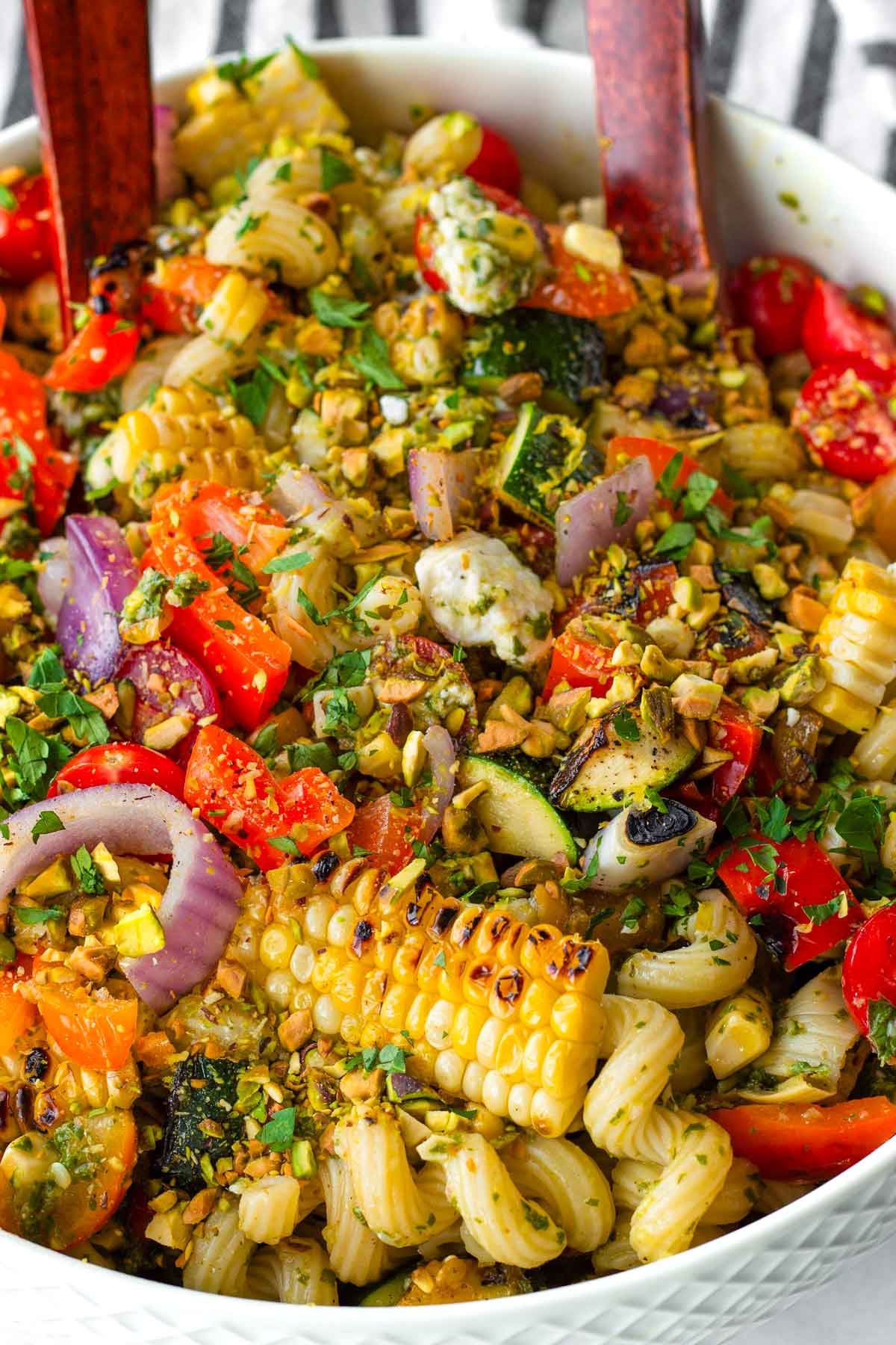 grilled vegetable pasta salad topped with pistachios in a bowl