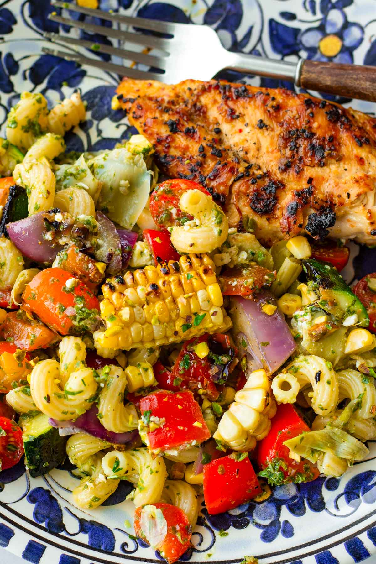 a serving of warm vegetable pasta salad with grilled chicken breast
