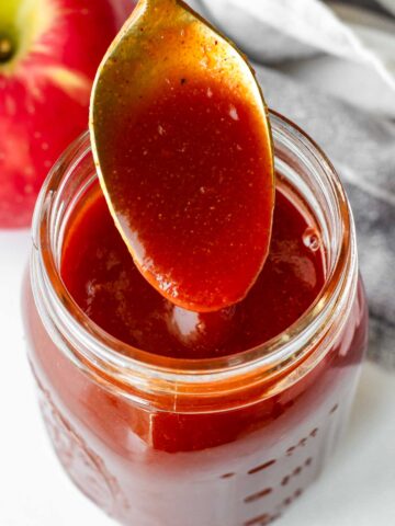 a spoonful of apple cider bbq sauce from a mason jar