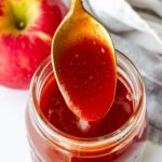 a spoonful of apple cider bbq sauce in a mason jar
