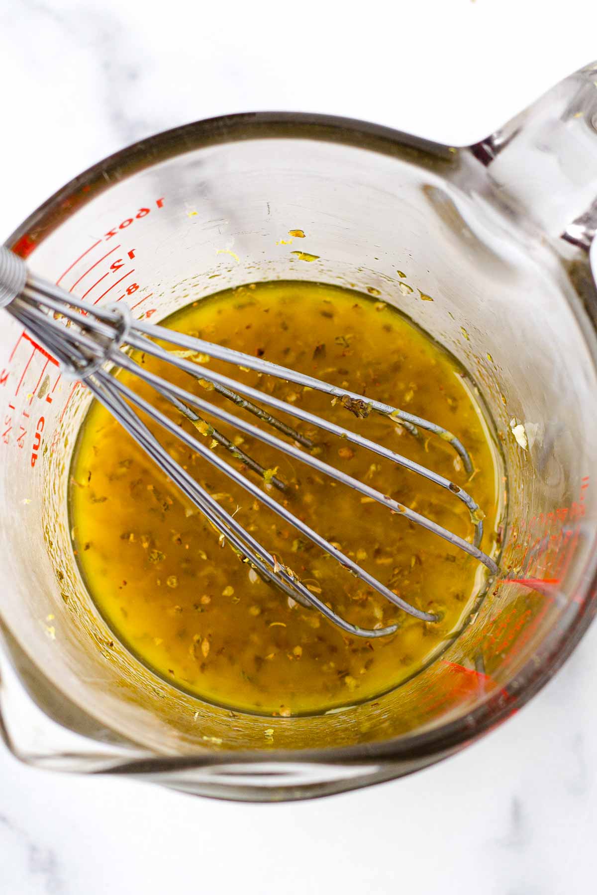 whisking lemon dressing in a cup