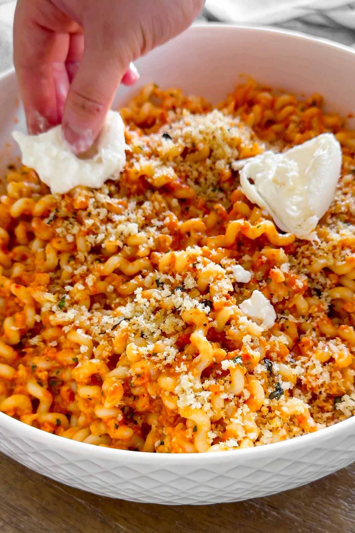 topping pasta with torn burrata
