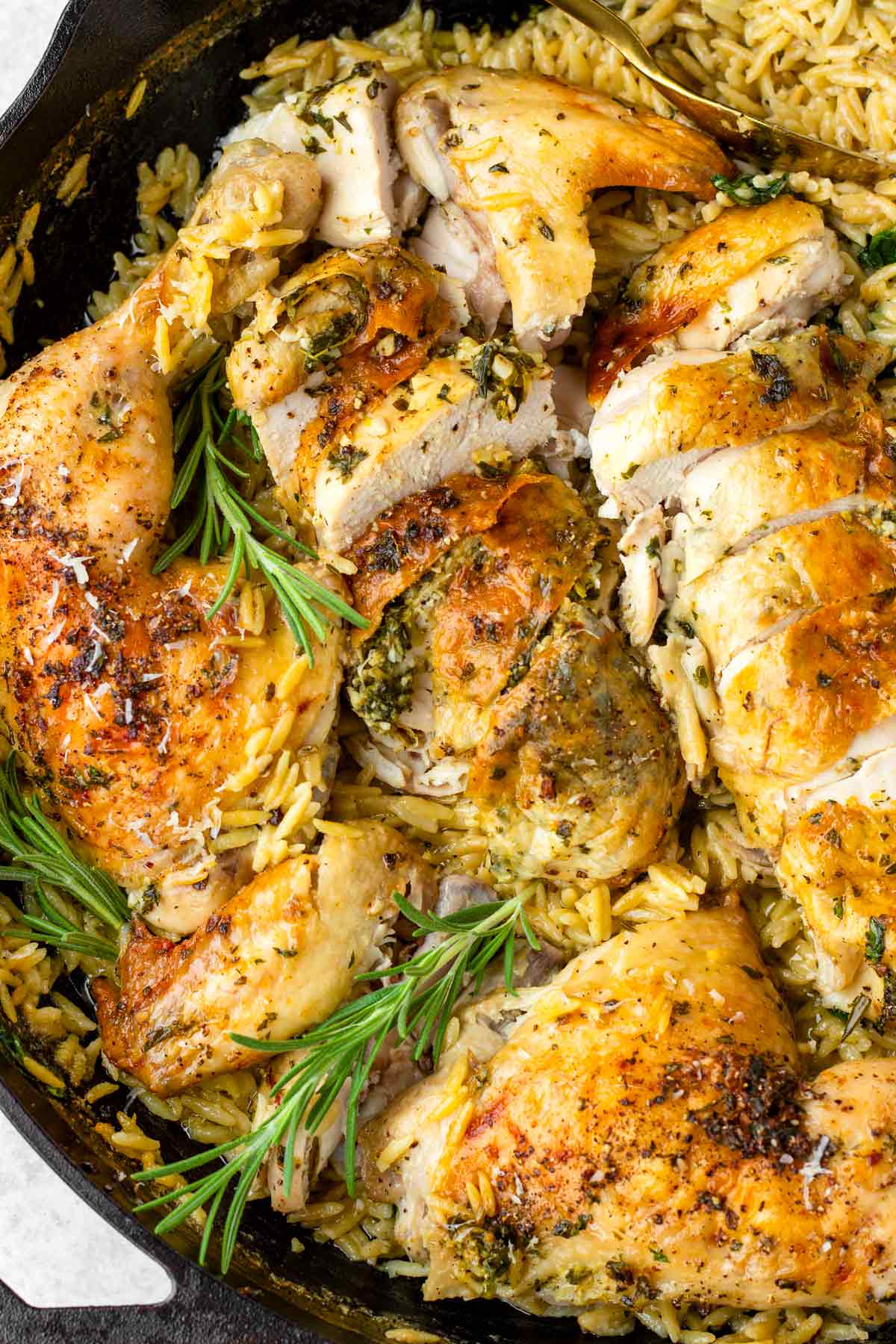 cut up whole herbed chicken on top of orzo
