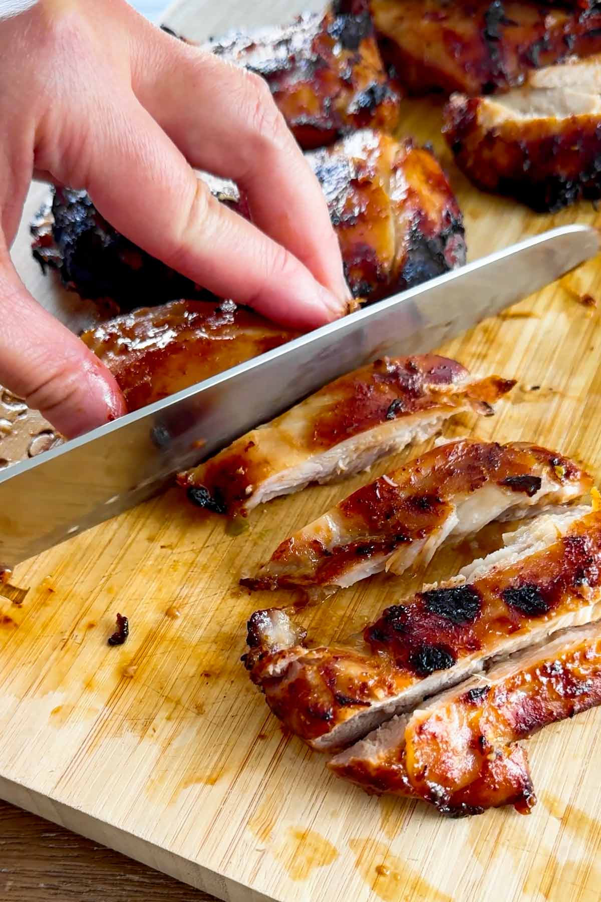 slicing chicken on a cutting board