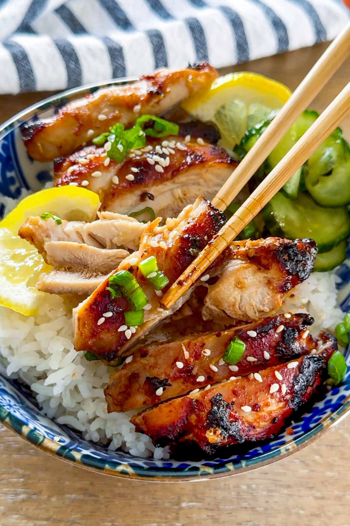 chopstick picking up a piece of sliced miso chicken