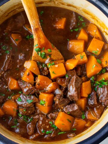 beef stew with butternut squash in blue dutch oven