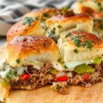 two cheesy and loaded philly cheesesteak sliders with garlic butter