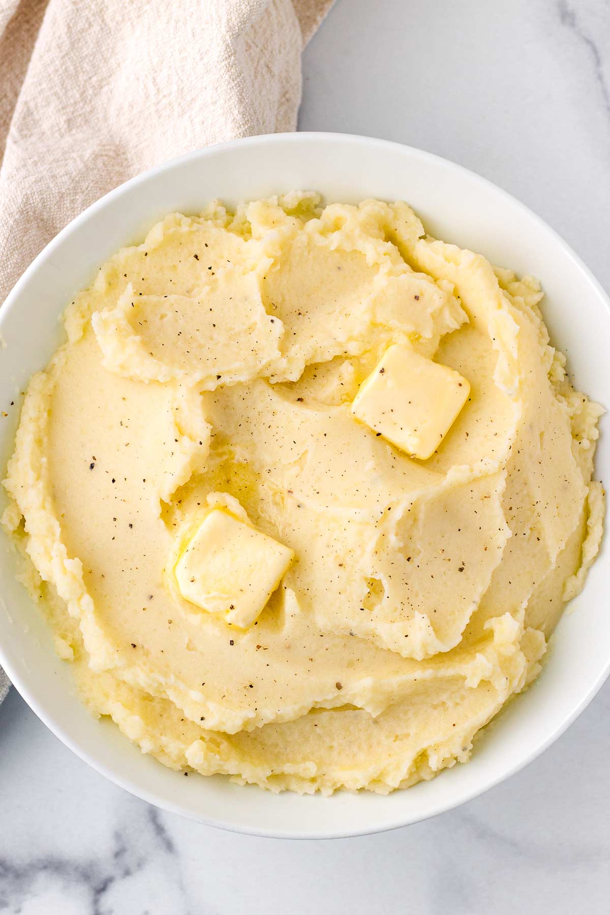 bowl with fluffy mashed potatoes with butter dollops