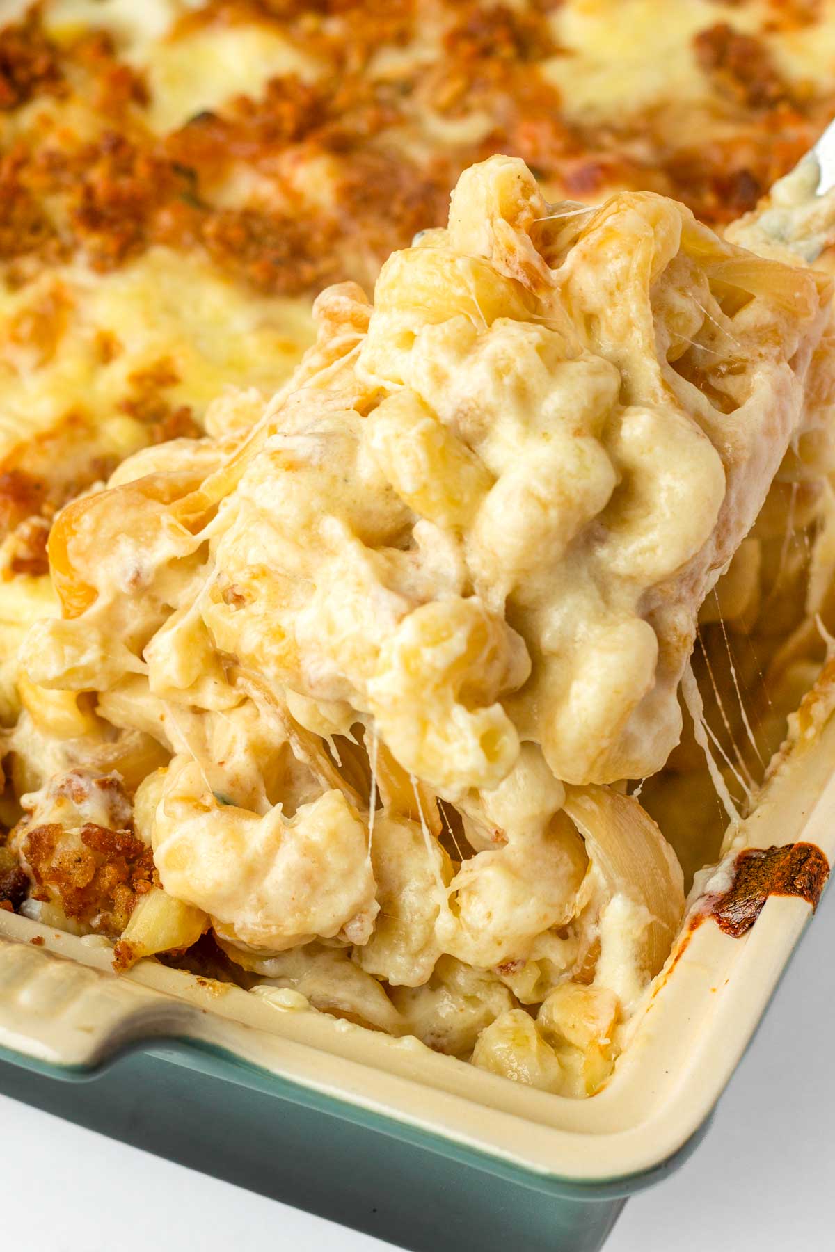 cheese pull of french onion mac and cheese in baking pan