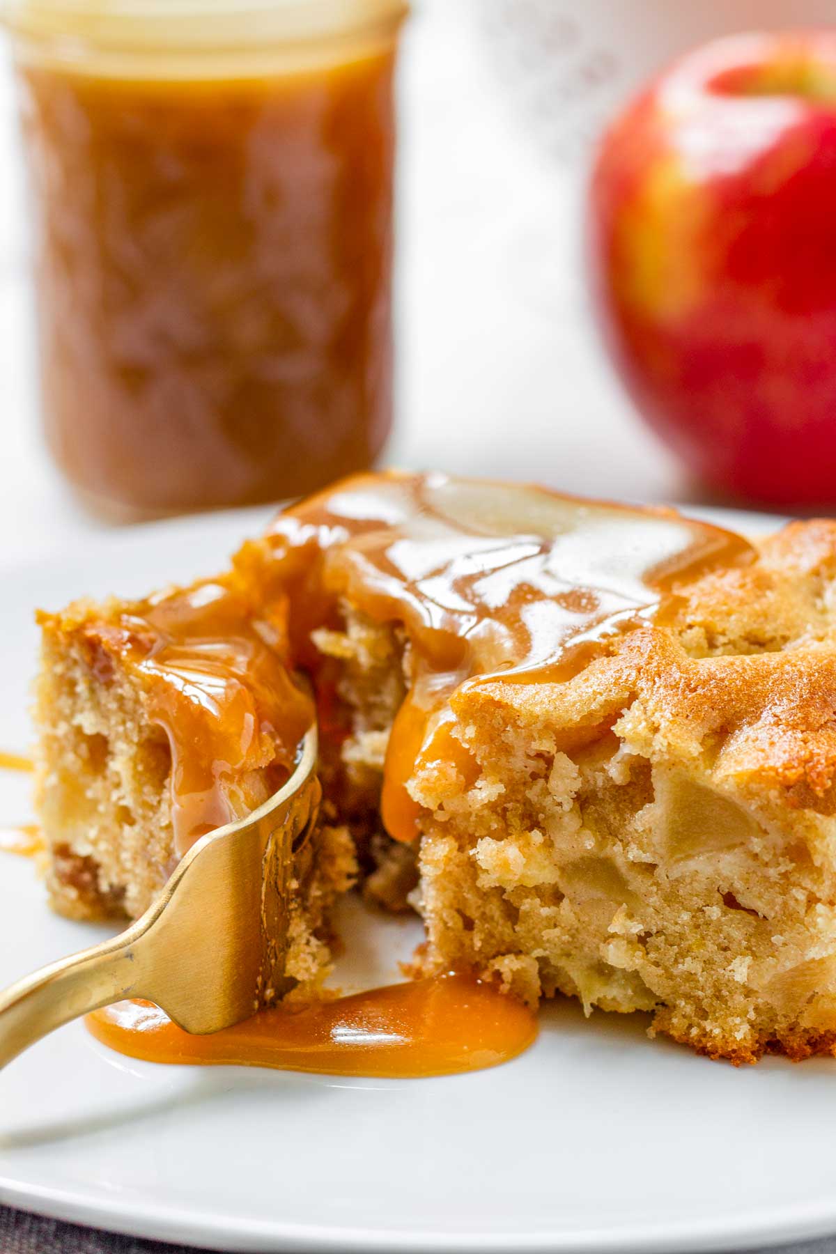fork cutting through a piece of apple cake