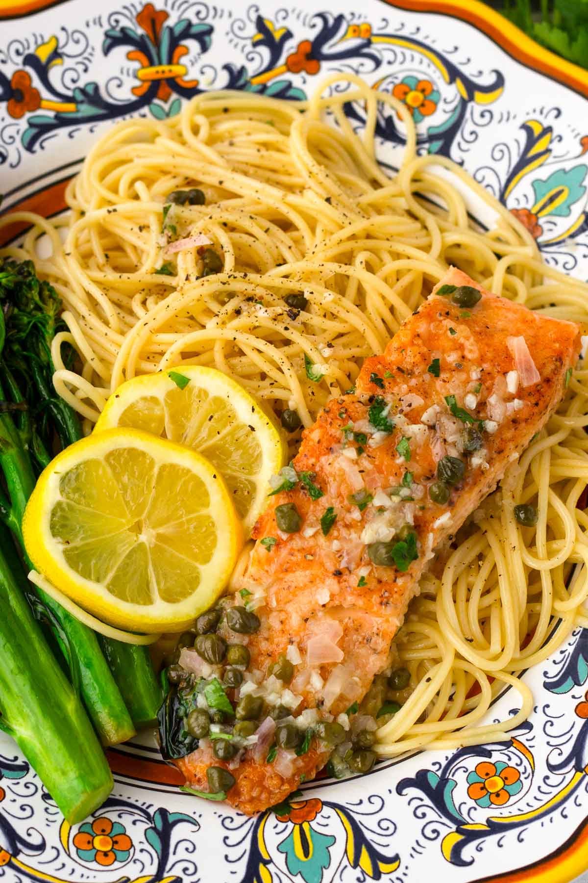 a serving of salmon piccata with pasta and broccolini