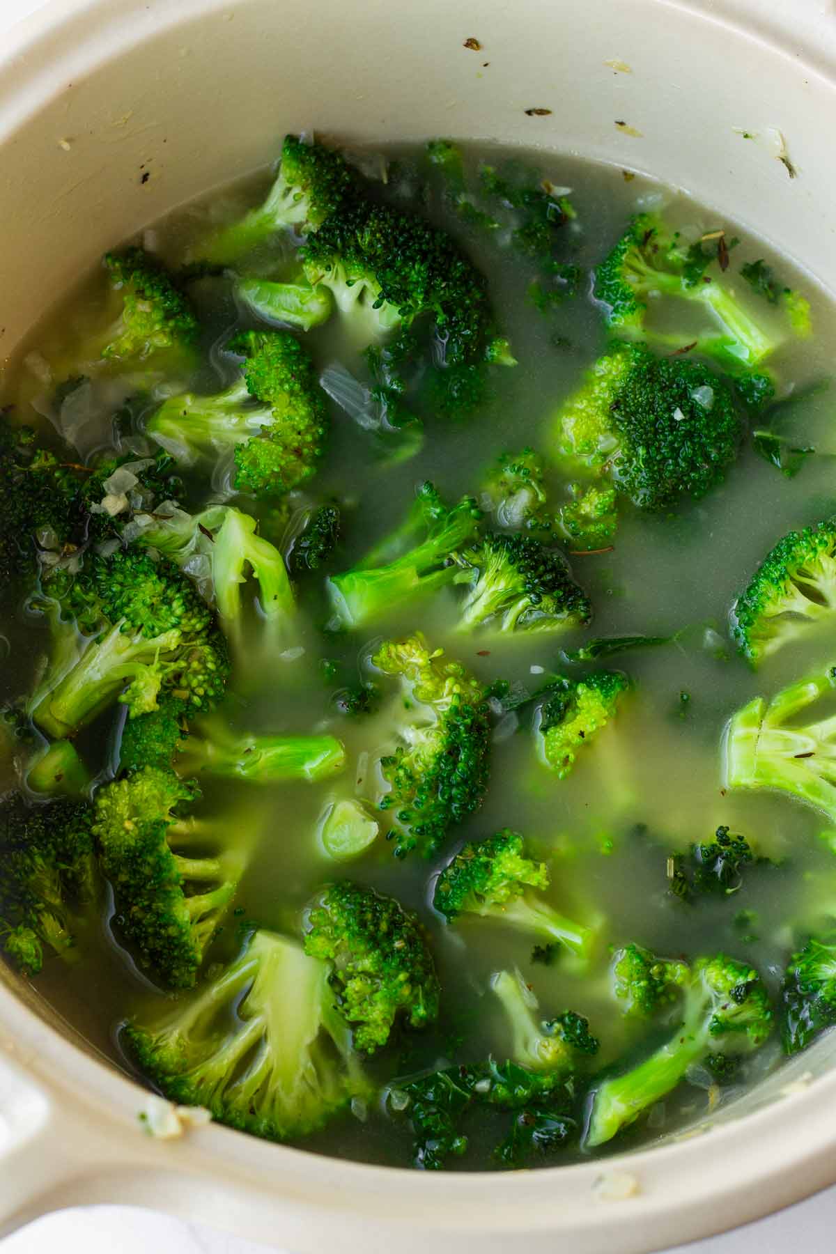 adding broth to the dutch oven