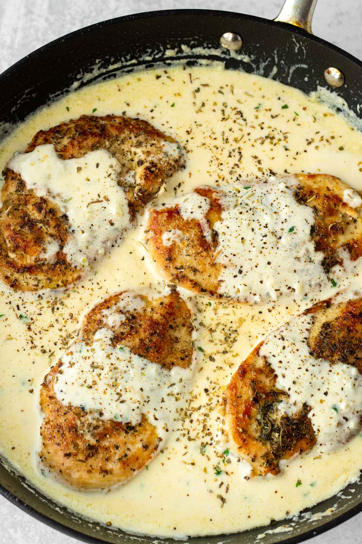 adding chicken back into the pan to simmer with the sauce