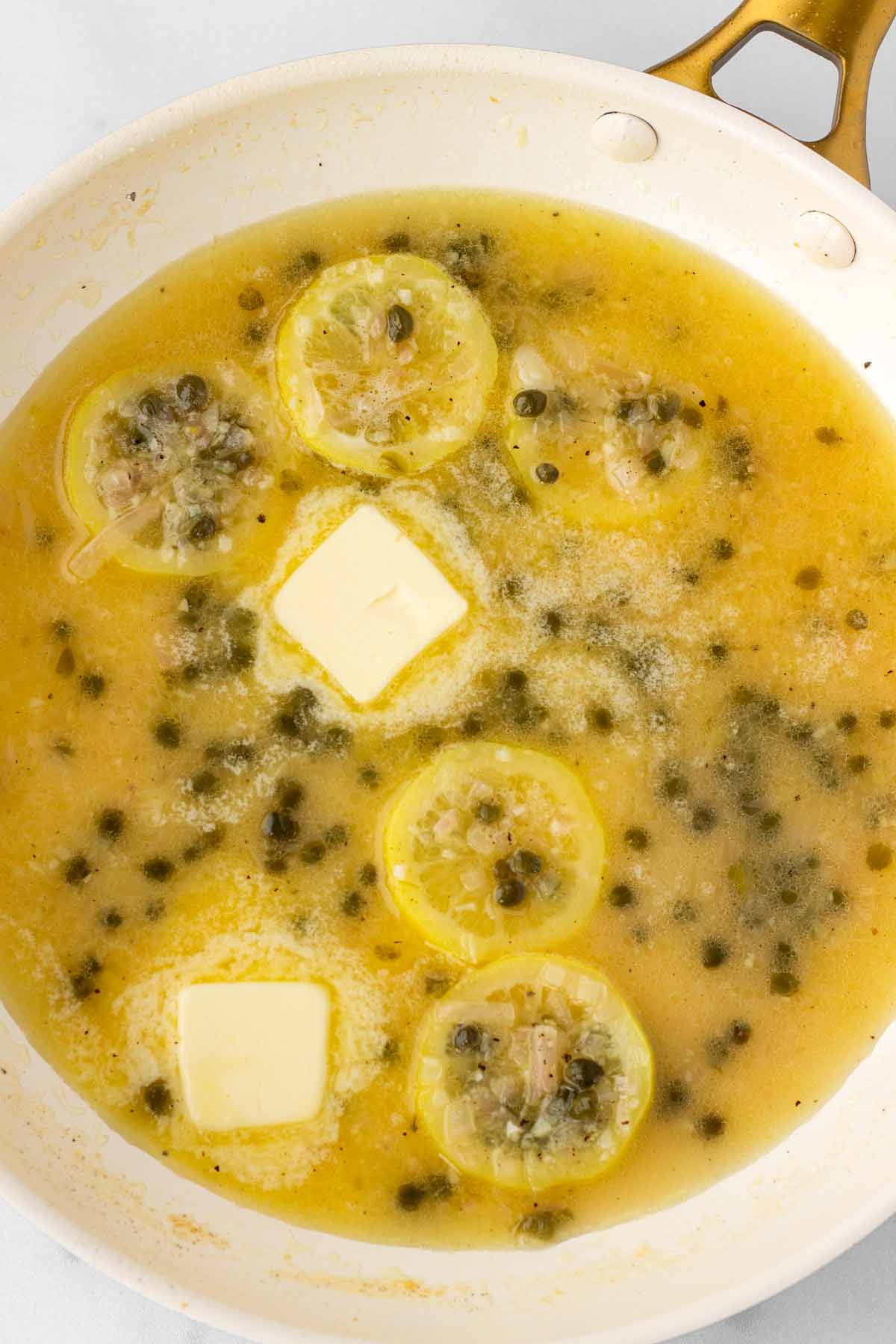 adding butter to thicken the sauce in the pan
