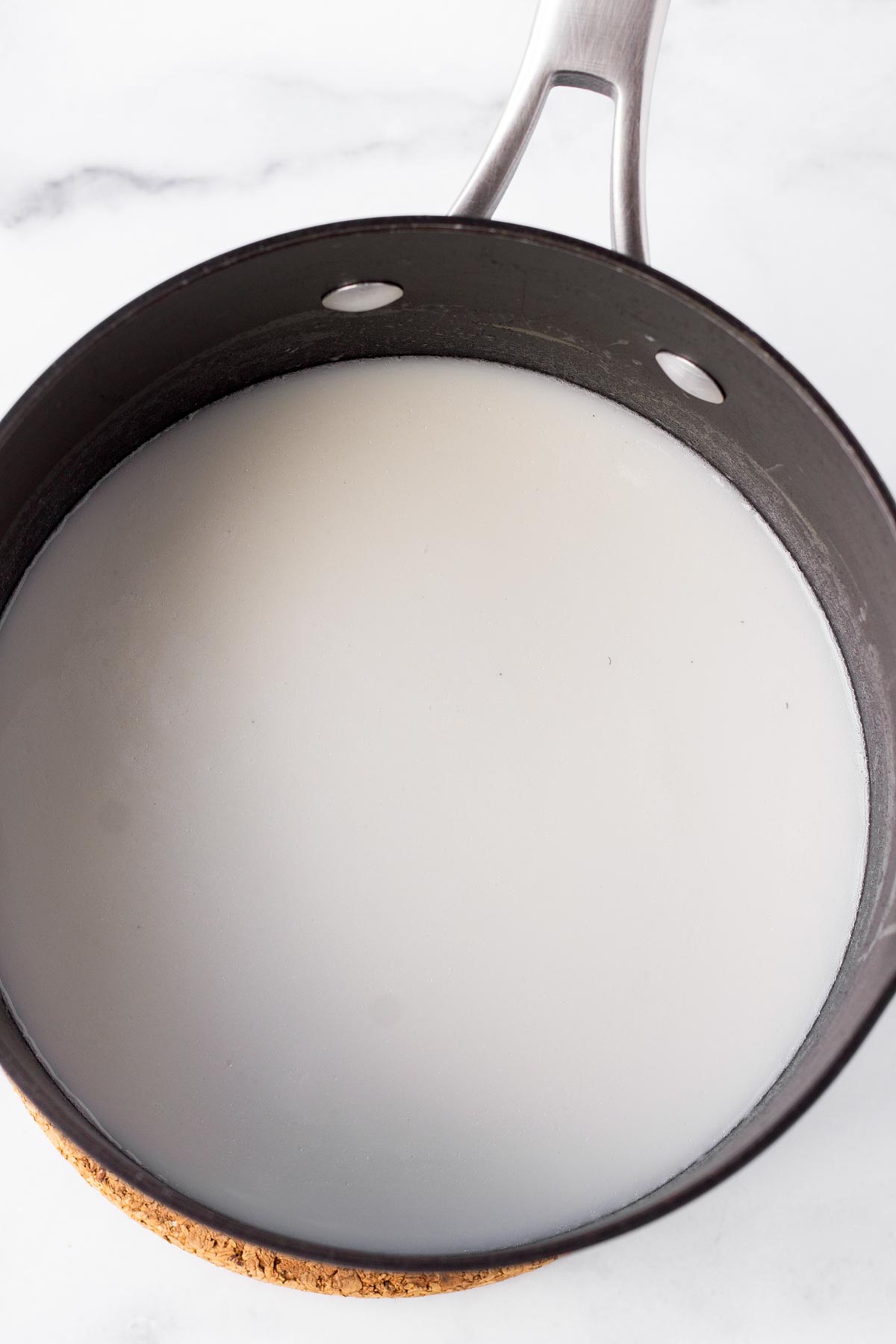 liquid and rice inside a medium saucepan before cooking