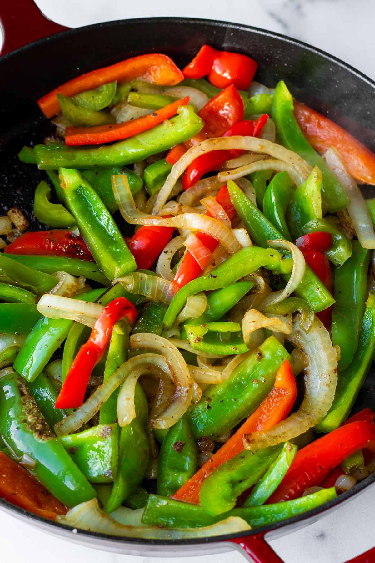 sauteeing bell peppers and onions in the skillet