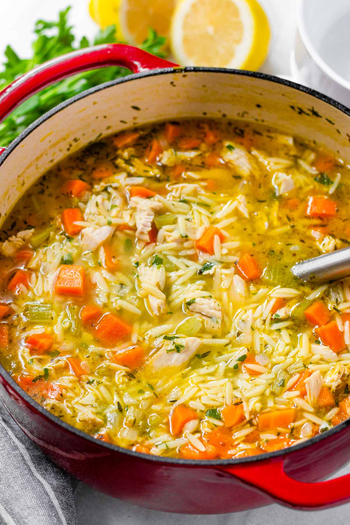 turkey orzo soup in a red dutch oven