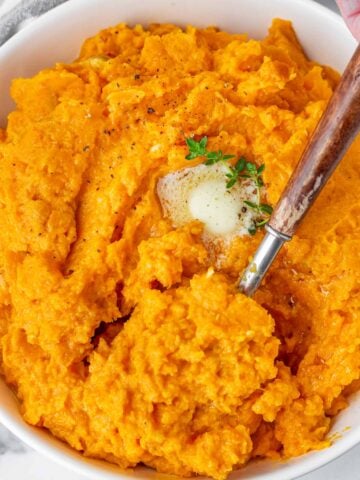spooning mashed sweet potatoes from bowl