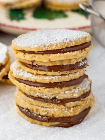 nutella shortbread sandwich cookies stacked with confectioners sugar dusting