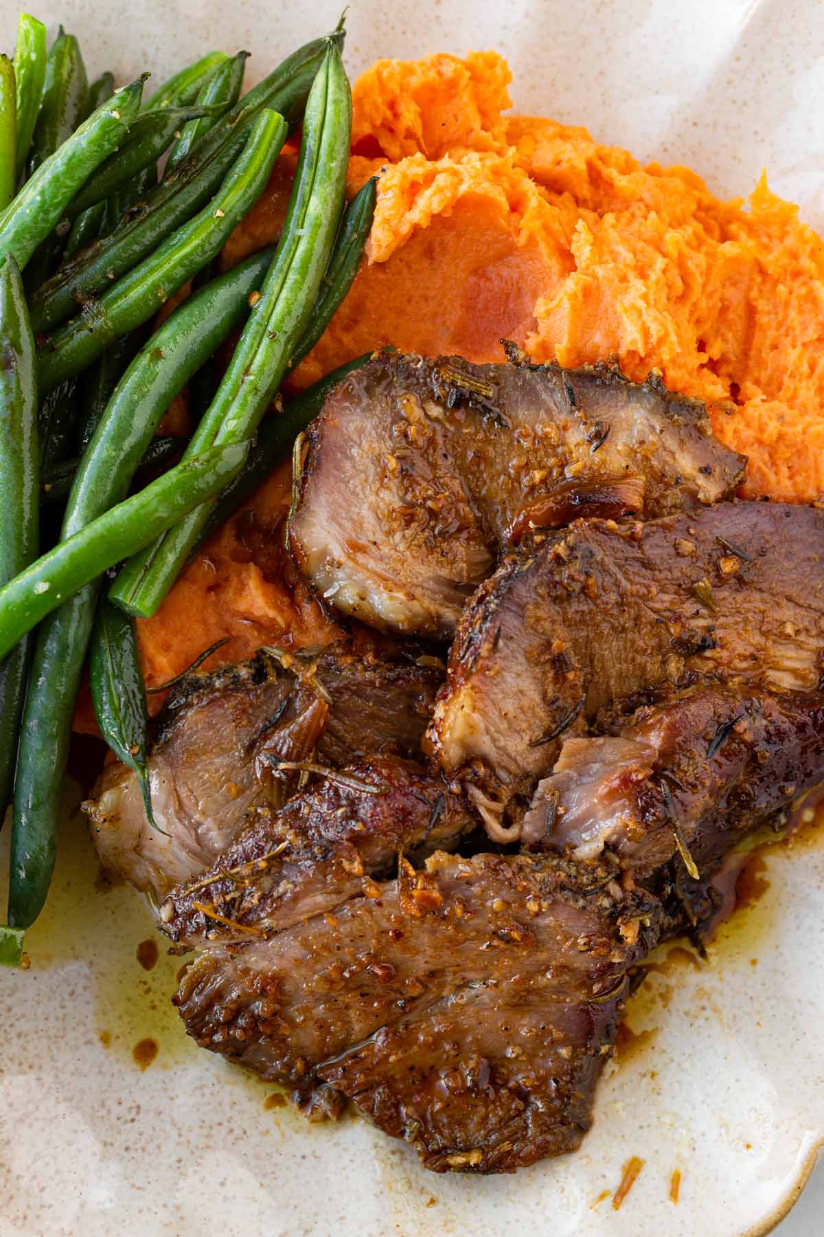 for slices of pork shoulder roast served with mashed potatoes and green beans