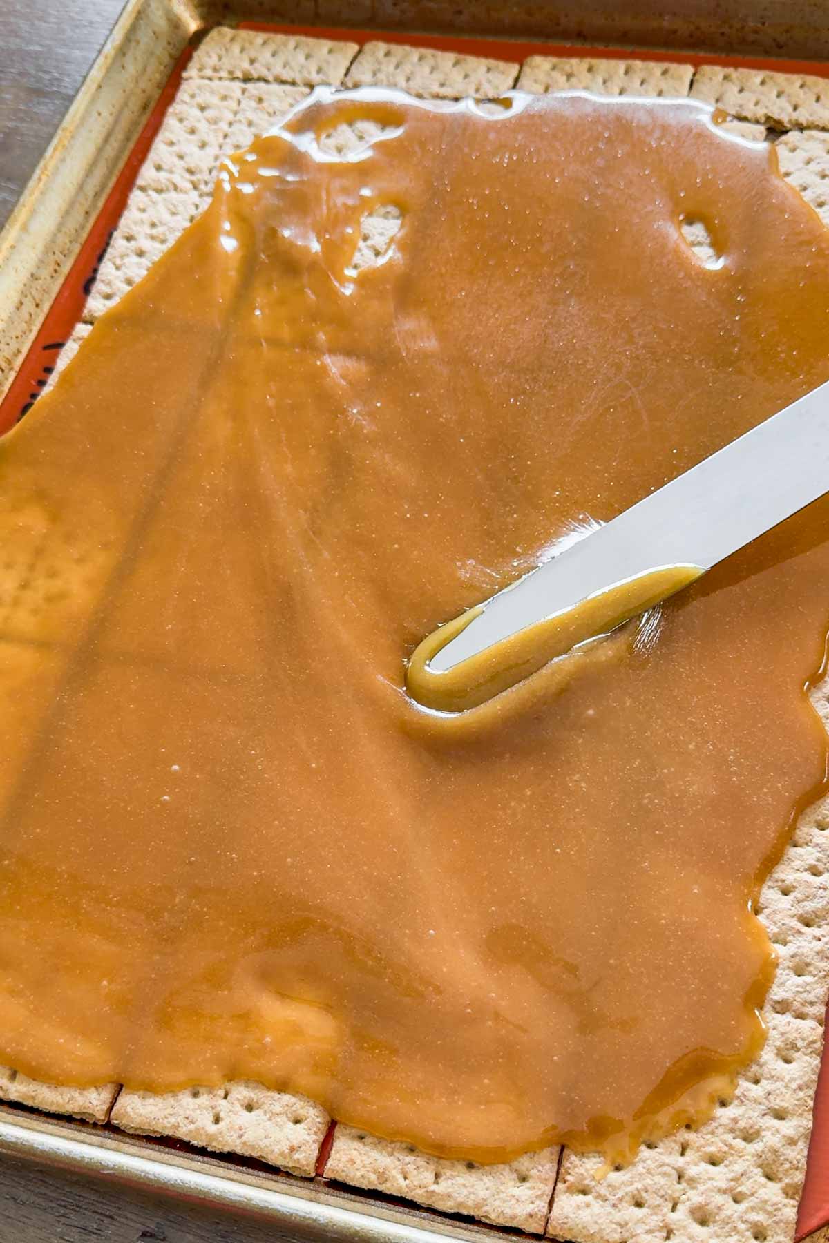 spreading caramel on top of the graham crackers