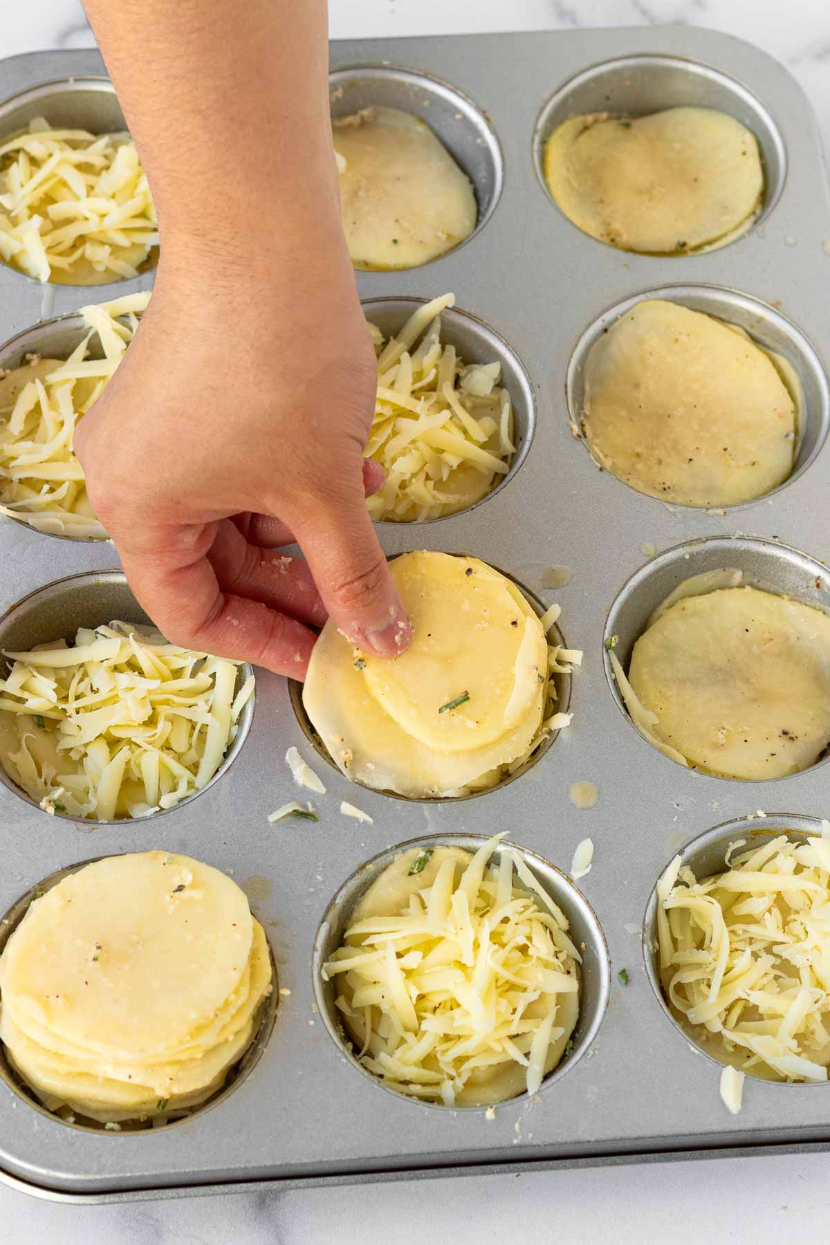 assembling potato stacks in a muffin pan