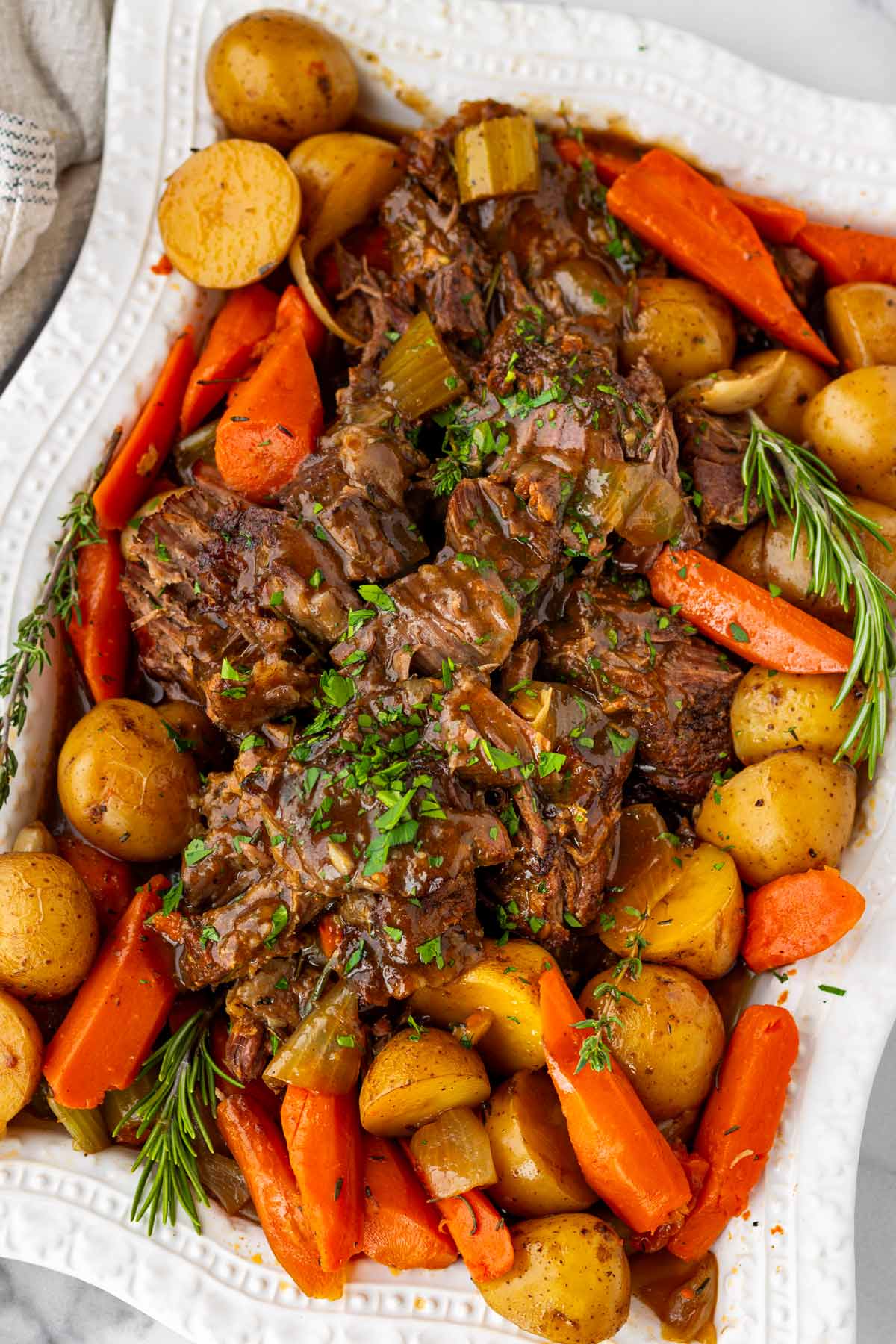 arranged pot roast with gravy, potatoes, carrots on a platter