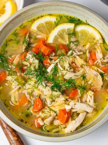 bowl of lemon chicken orzo soup with dill garnish